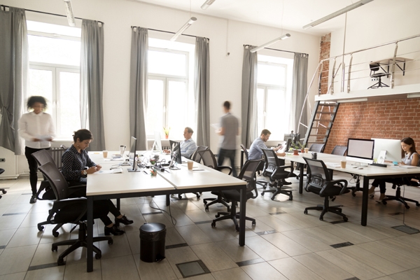 Corporate staff employees working together using computers at coworking